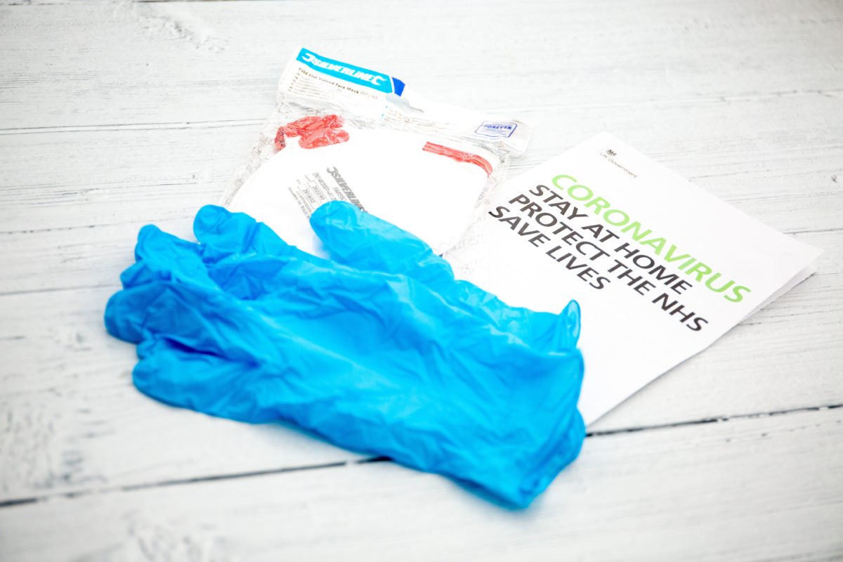 A Blue Glove Next To A Mask And A Handout Of Coronavirus Information